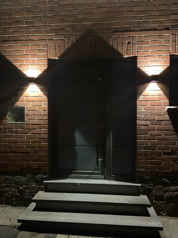 Porte d’entrée éclairée par deux appliques haut et bas