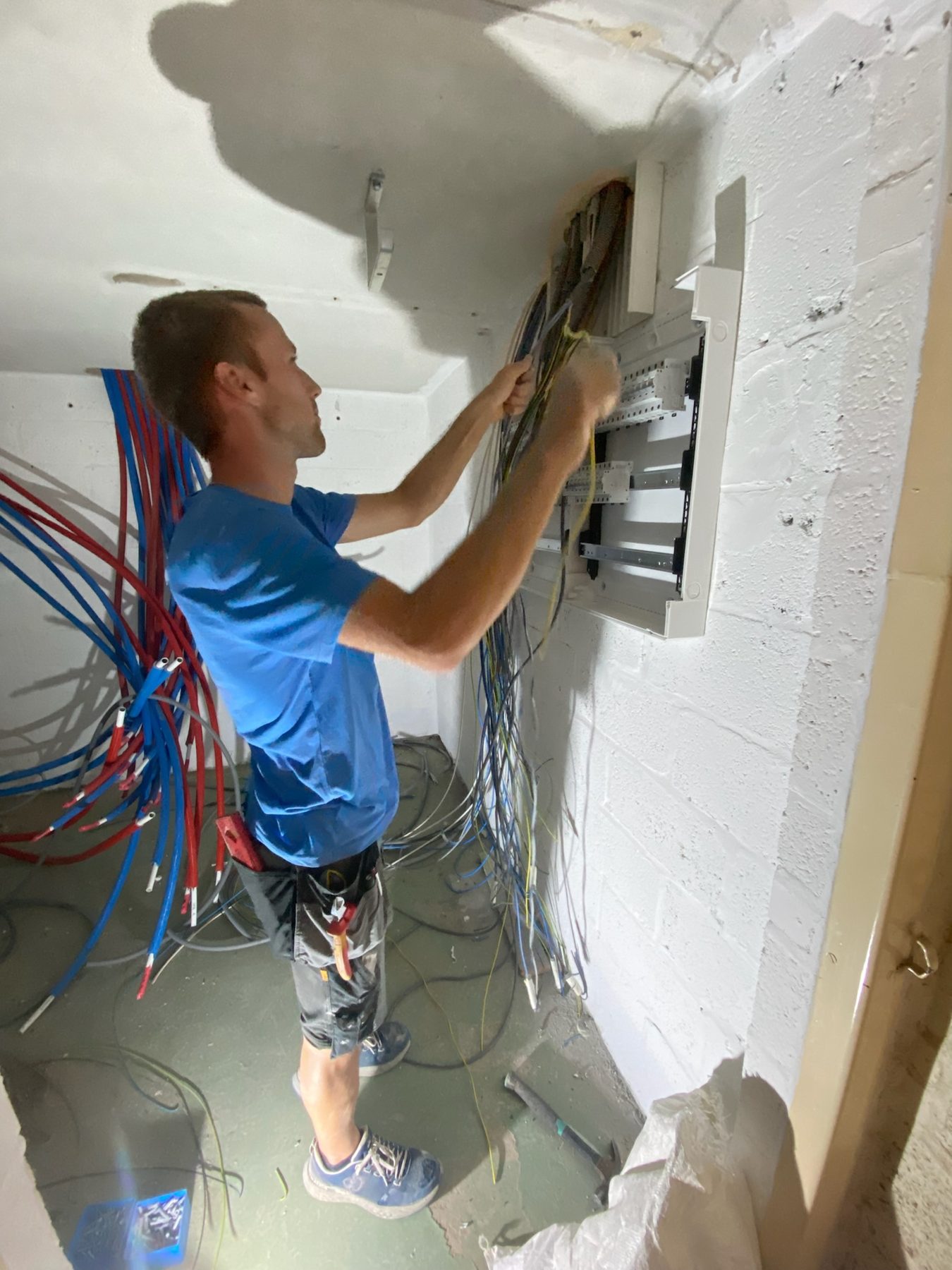Installateur en train de câbler un coffret électrique