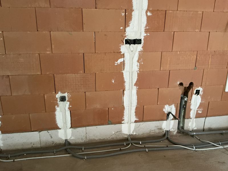 Gaines au sol et boîtes d’encastrement sur un mur en briques