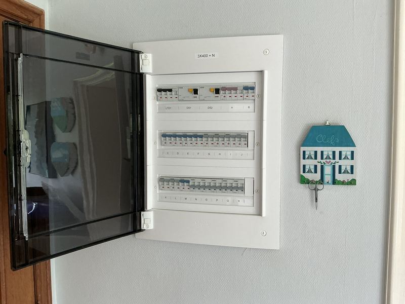 Tableau électrique ouvert avec disjoncteurs et circuits repérés